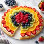 Delicious easy fruit pizza topped with colorful fresh fruits and creamy frosting.