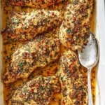 Plate of Garlic Chicken Parmesan garnished with herbs and served with pasta.