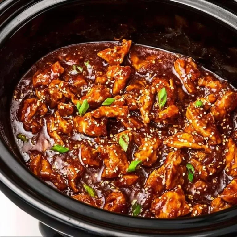 Delicious slow cooker honey garlic chicken garnished with green onions.