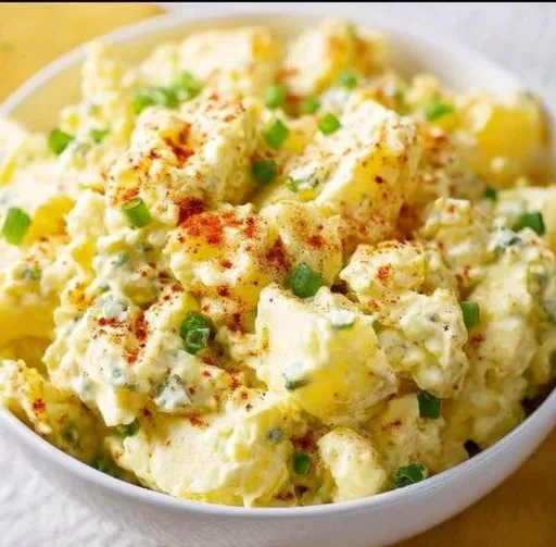 Southern potato salad in a bowl garnished with herbs