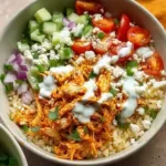 Delicious Buffalo Chicken Rice Bowl topped with fresh vegetables and spicy sauce