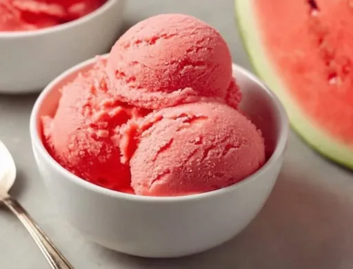 Homemade watermelon ice cream in a bowl garnished with fresh mint leaves.